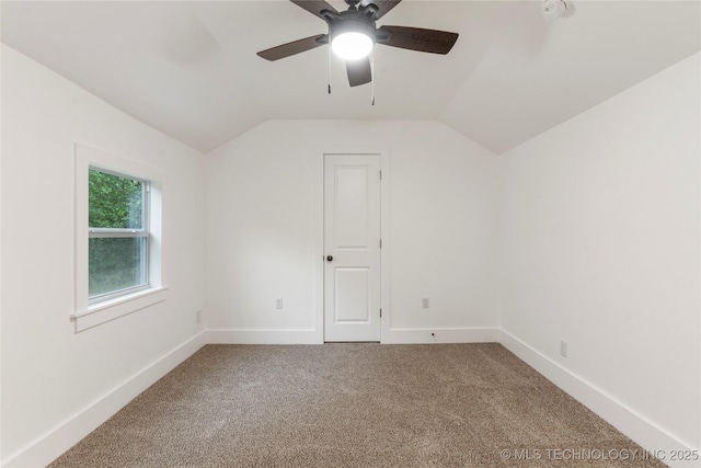 interior space with vaulted ceiling, baseboards, and carpet floors