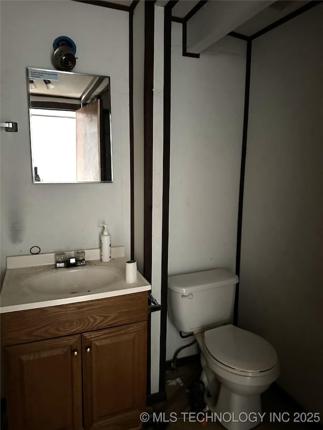 half bathroom featuring toilet and vanity