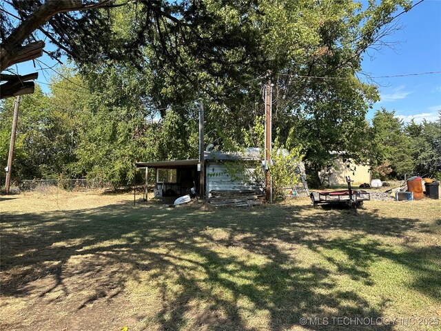 view of yard with fence, an outdoor structure, and a shed