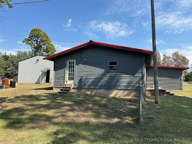 back of house featuring a yard and entry steps