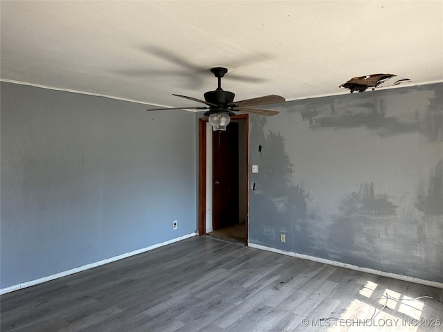 spare room with ceiling fan, baseboards, and wood finished floors
