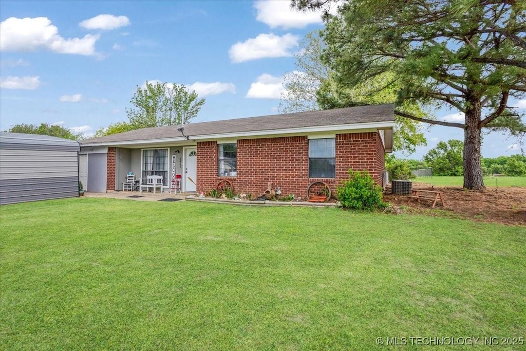 back of house featuring a lawn and brick siding