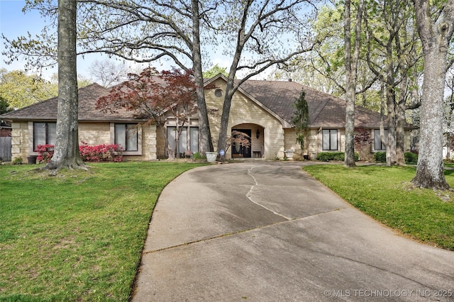 749 Brookhollow Ln, Bartlesville, OK 74006 - ranch-style home with stone siding, a front lawn, roof with shingles, and curved driveway