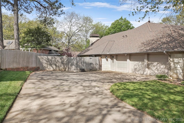 749 Brookhollow Ln, Bartlesville, OK 74006 - exterior space with a chimney, driveway, stone siding, an attached garage, and fence