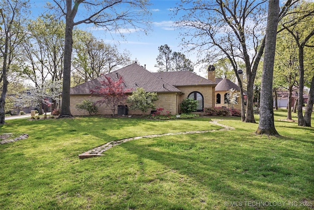 749 Brookhollow Ln, Bartlesville, OK 74006 - view of front facade featuring a chimney, a front lawn, brick siding, and a shingled roof