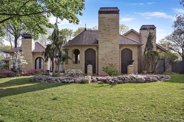 749 Brookhollow Ln, Bartlesville, OK 74006 - english style home with a front lawn, stone siding, and a chimney