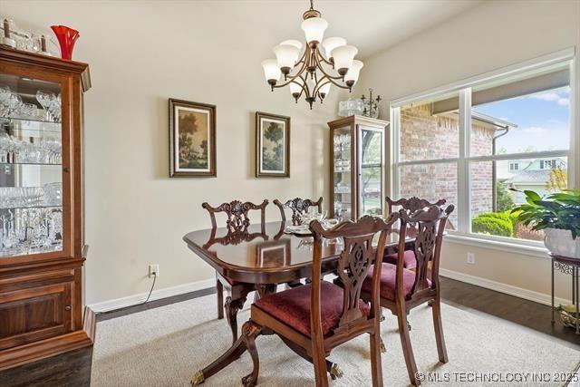 929 S 71st St, Broken Arrow, OK 74014 - dining space with baseboards, a chandelier, and wood finished floors