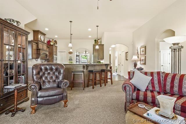 929 S 71st St, Broken Arrow, OK 74014 - carpeted living area featuring arched walkways and recessed lighting