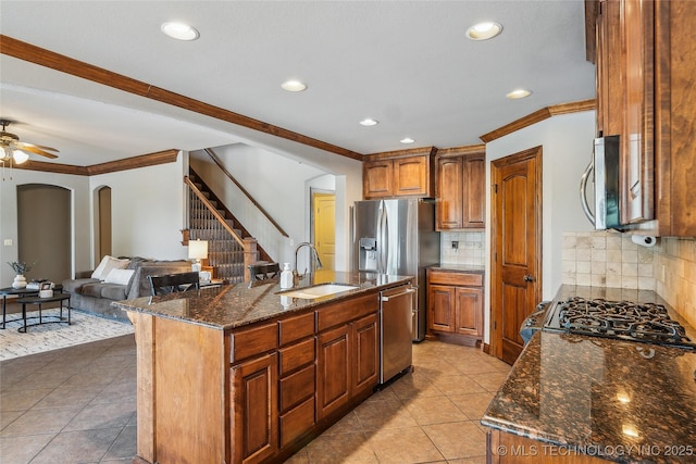 kitchen featuring a sink, arched walkways, recessed lighting, and appliances with stainless steel finishes