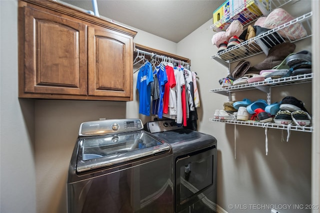 washroom featuring washing machine and dryer and cabinet space