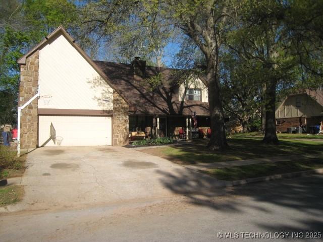 traditional-style home with concrete driveway and stone siding