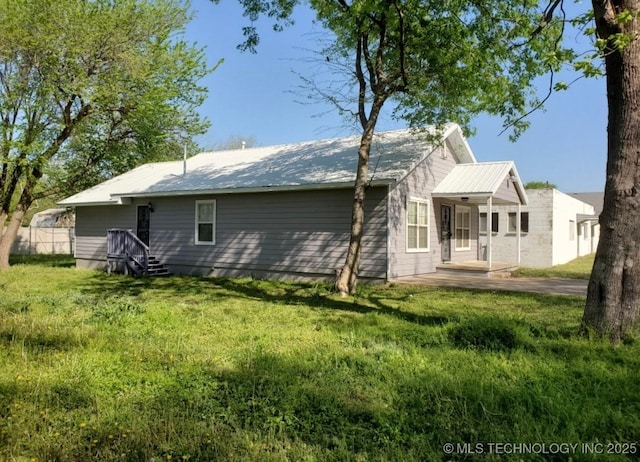 back of property with a lawn and metal roof