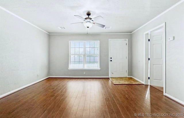 interior space with ceiling fan, baseboards, wood finished floors, and ornamental molding