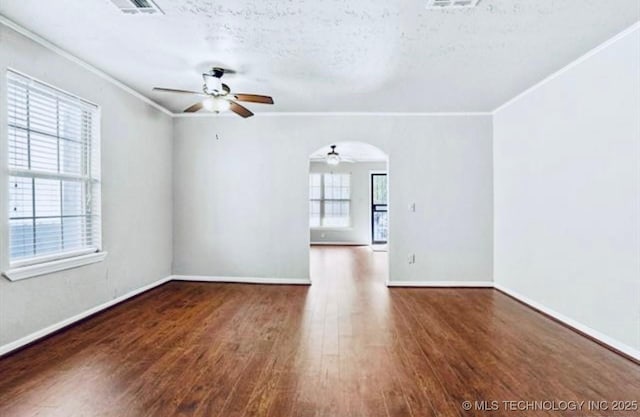 spare room with a textured ceiling, baseboards, a ceiling fan, wood finished floors, and ornamental molding