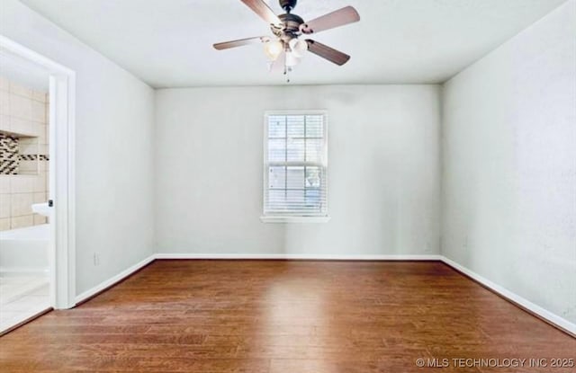 unfurnished room featuring wood finished floors, baseboards, and ceiling fan