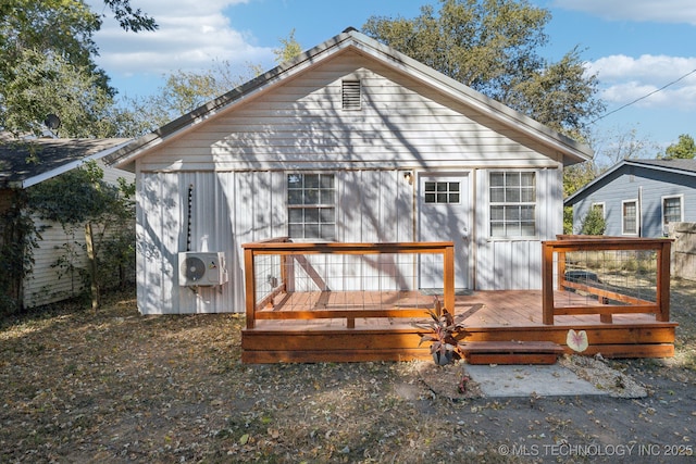 rear view of house featuring a wooden deck