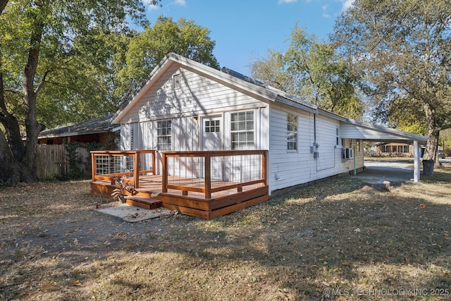 rear view of property featuring an attached carport and a deck