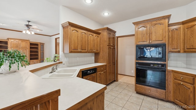 kitchen with light countertops, backsplash, a sink, and black appliances