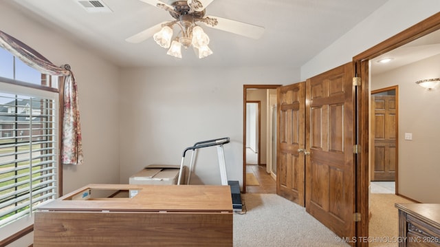 office area featuring light colored carpet, a ceiling fan, and visible vents