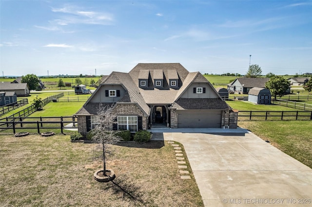 view of front facade featuring a storage shed, driveway, stone siding, fence, and a front yard