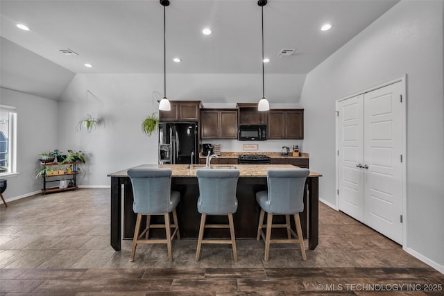 kitchen featuring black appliances, lofted ceiling, visible vents, and a kitchen island with sink