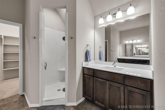 bathroom featuring vanity, baseboards, and a shower stall