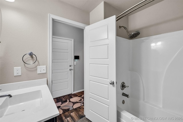 bathroom featuring vanity, wood finished floors, and shower / tub combination