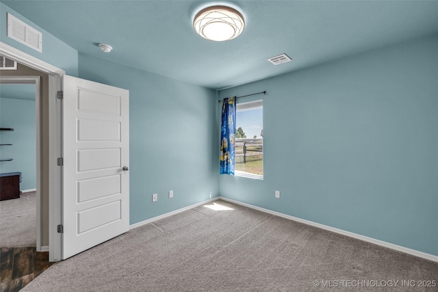 spare room with baseboards, visible vents, and carpet