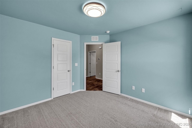 unfurnished bedroom with baseboards, visible vents, and carpet