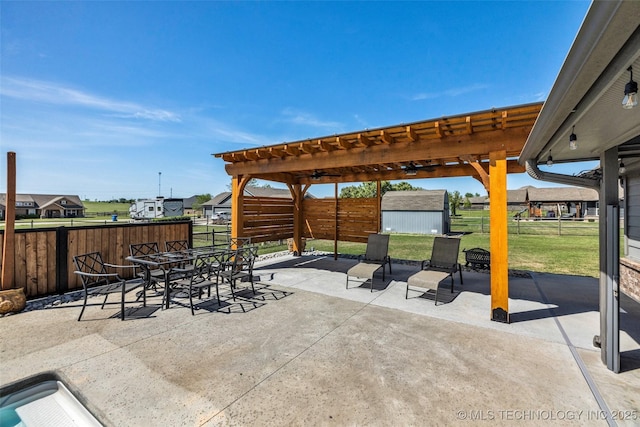 view of patio with a fenced backyard, an outbuilding, outdoor dining space, and a shed