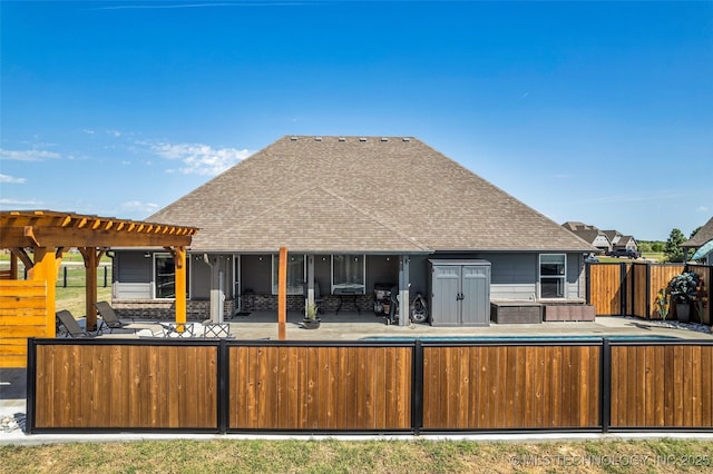 back of house featuring a pergola, a patio area, a shingled roof, and a fenced backyard