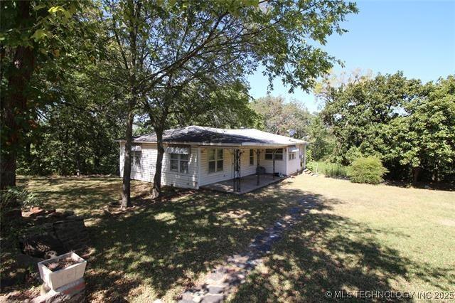 988 Wilson St, Durant, OK 74701 - rear view of house featuring a lawn and a patio area