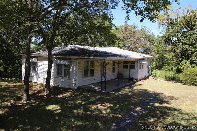 988 Wilson St, Durant, OK 74701 - rear view of house with a patio area and a lawn