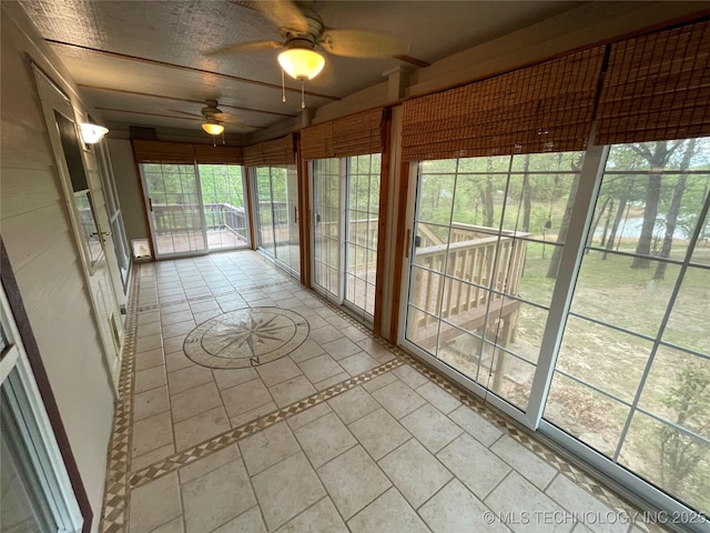 unfurnished sunroom featuring a ceiling fan