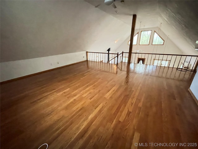 additional living space featuring baseboards, a ceiling fan, wood finished floors, and vaulted ceiling
