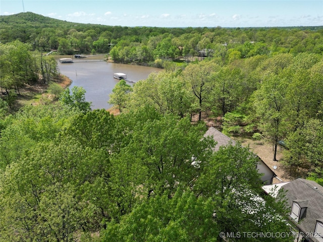 aerial view featuring a wooded view and a water view
