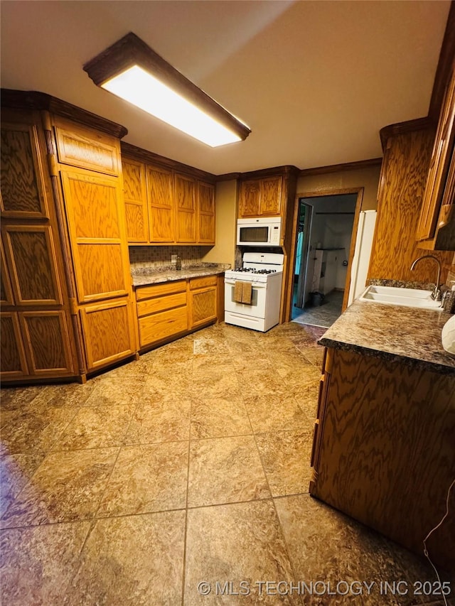 503 NW 2nd St, Checotah, OK 74426 - kitchen with brown cabinets, backsplash, a sink, and white appliances