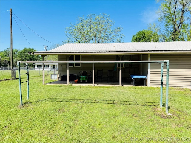 503 NW 2nd St, Checotah, OK 74426 - back of house with fence, a yard, and metal roof