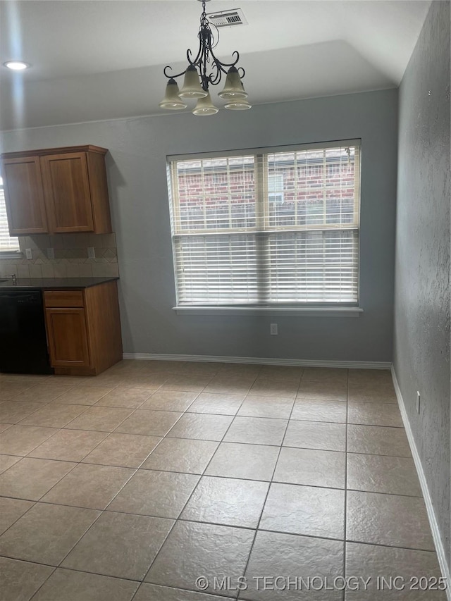 unfurnished dining area with vaulted ceiling, visible vents, a notable chandelier, and light tile patterned floors