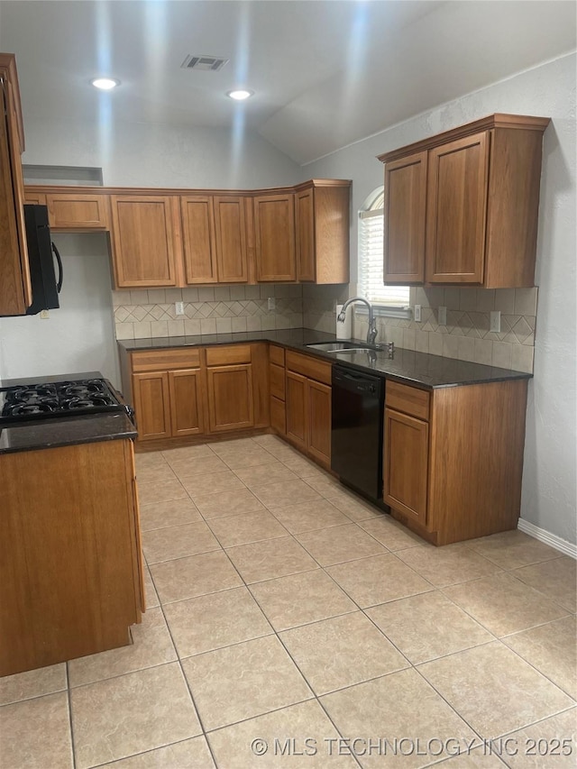 kitchen with dark countertops, brown cabinetry, a sink, black dishwasher, and tasteful backsplash