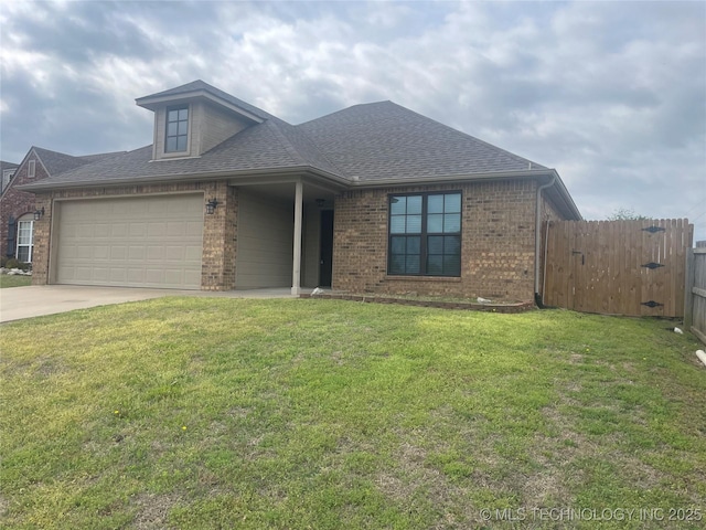 view of front of property featuring fence, a shingled roof, concrete driveway, brick siding, and a front yard