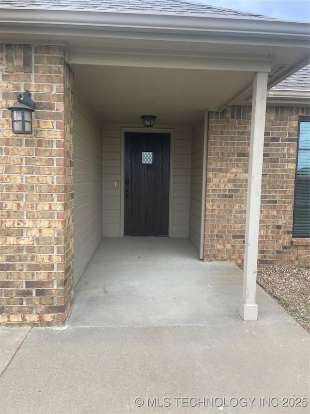 doorway to property with brick siding