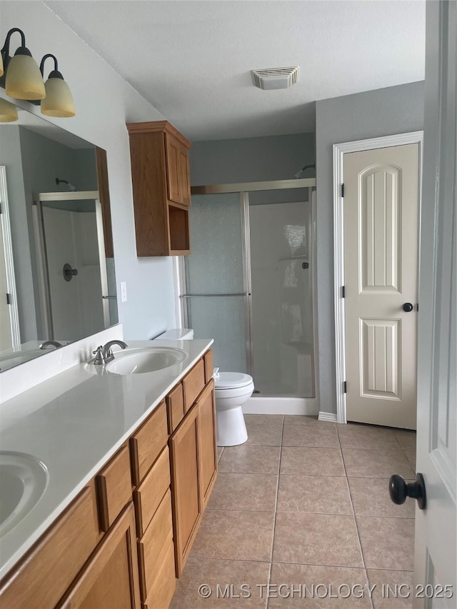 bathroom with tile patterned floors, double vanity, visible vents, a sink, and a stall shower