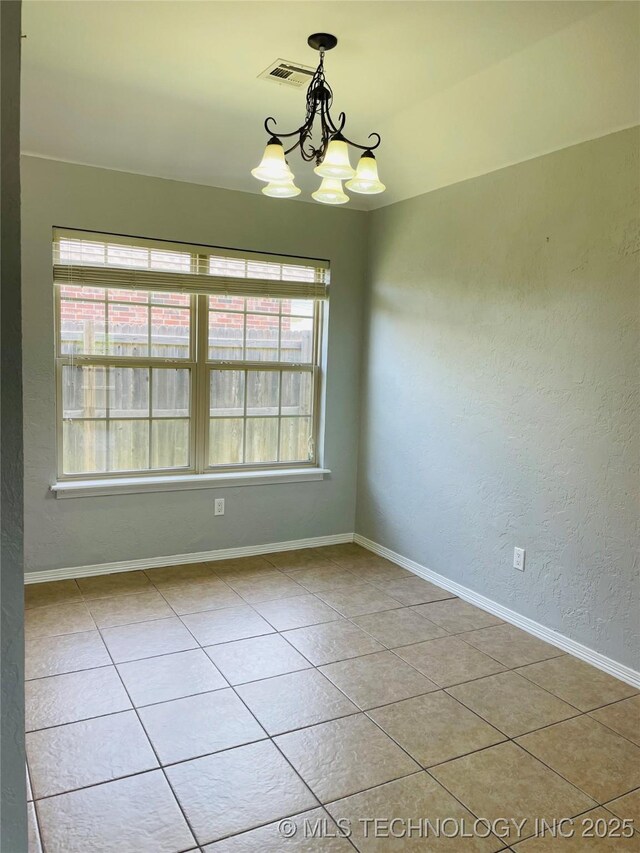 9700 E 110th St N, Owasso, OK 74055 - spare room with a chandelier, plenty of natural light, light tile patterned flooring, and a textured wall