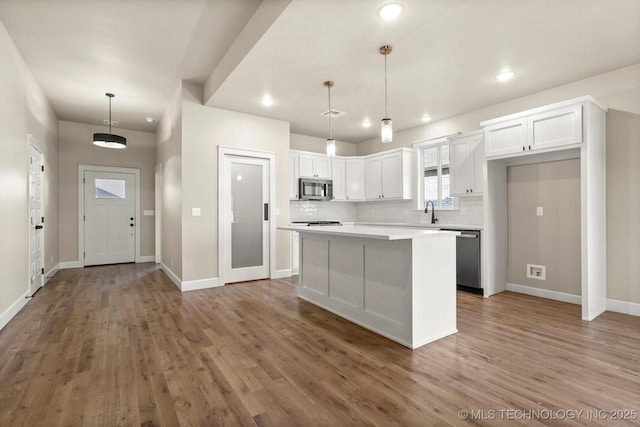 4231 W 4th St, Skiatook, OK 74070 - kitchen featuring stainless steel appliances, white cabinetry, a kitchen island, wood finished floors, and recessed lighting
