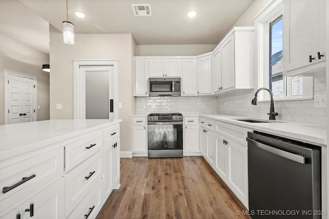 4231 W 4th St, Skiatook, OK 74070 - kitchen featuring appliances with stainless steel finishes, decorative backsplash, white cabinets, light countertops, and recessed lighting