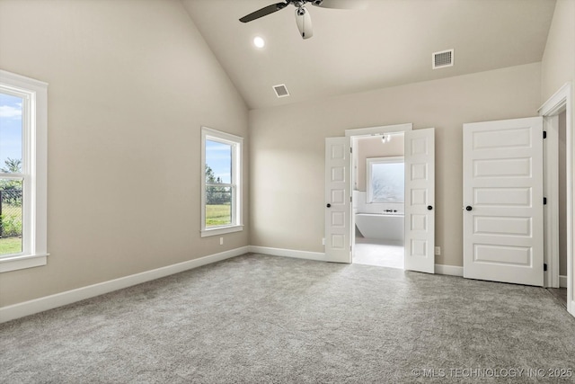 4231 W 4th St, Skiatook, OK 74070 - unfurnished bedroom with multiple windows, high vaulted ceiling, connected bathroom, and carpet flooring