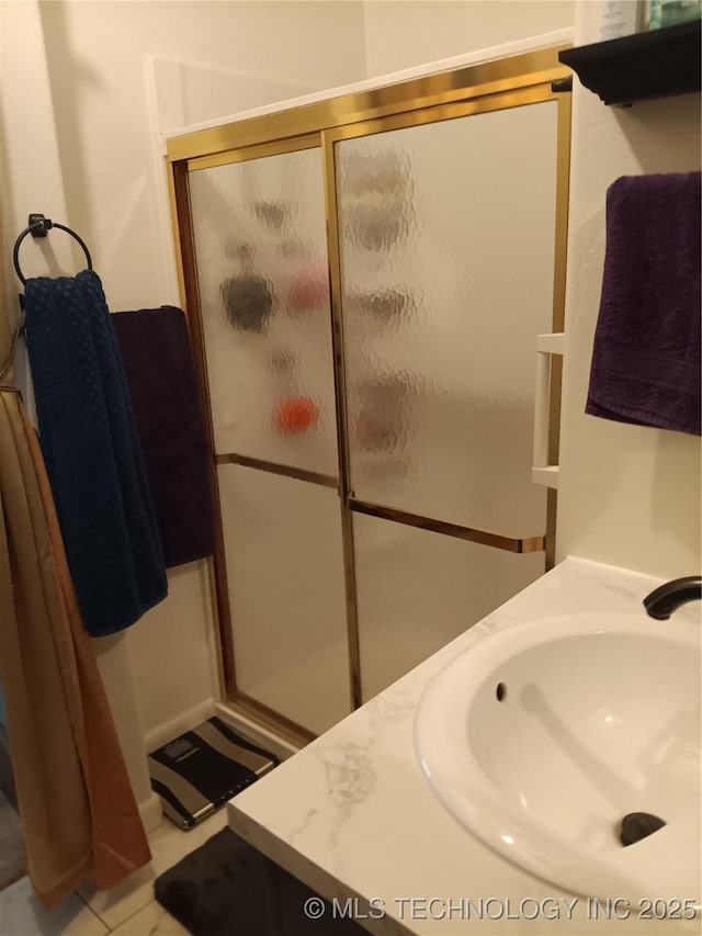 full bath with a shower stall and a sink