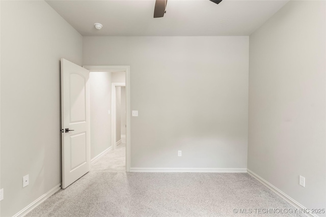 carpeted spare room with baseboards and ceiling fan