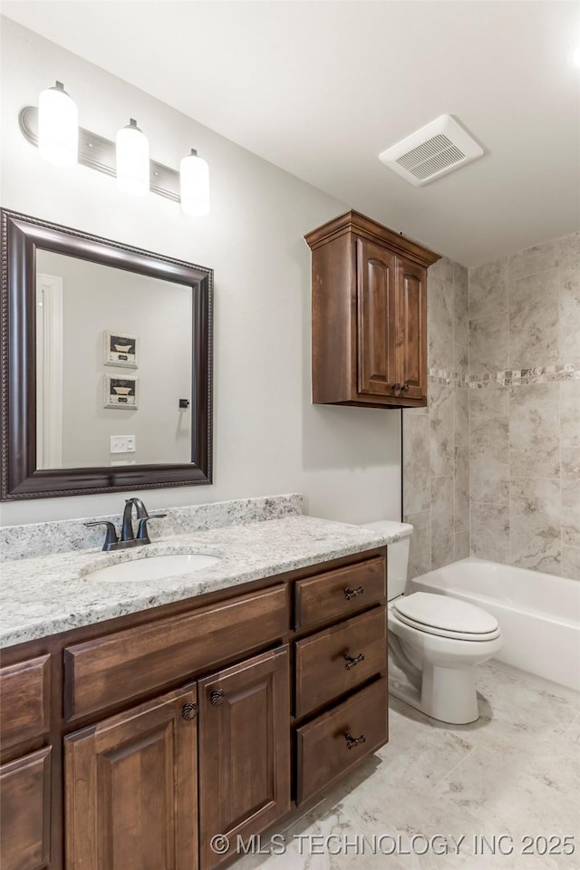 bathroom featuring toilet, vanity, and visible vents